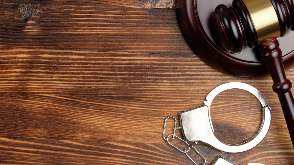 Judge hammer with handcuffs on wooden background with copy space.