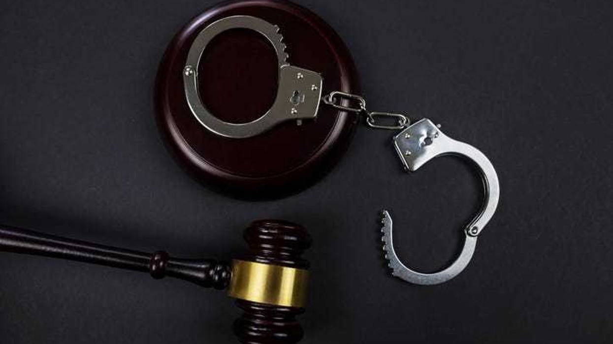 judge's gavel and handcuffs on a black background