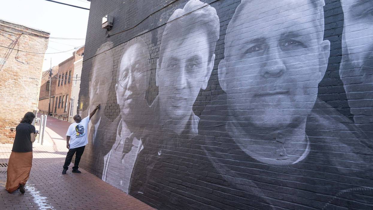 Jul 20, 2022; Washington, DC, United States; Roger Rusesabagina touches an image of his father Paul Rusesabagina, who has been held in Rwanda since August 31, 2020, which is part of a mural honoring 18 wrongfully detained Americans is unveiled in Washington DC on Wednesday, July 20, 2022. One of those honored on the mural is Paul Whelan, image shown to the right, who has been detained in Russia since 2018. Whelan is a former US Marine and convicted by Russian officials on espionage charges in 2020.