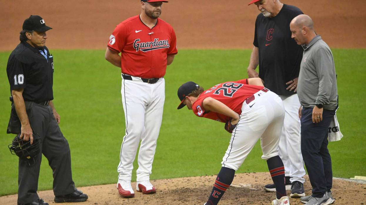 Jul 24, 2024; Cleveland, Ohio, USA; Cleveland Guardians starting pitcher Tanner Bibee (28) stretches beside manager Stephen Vogt (12) and pitching coach Carl Willis (51) before leaving the game in the fifth inning against the Detroit Tigers at Progressive Field.