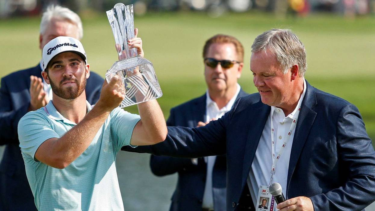 Jul 7, 2019; Blaine, MN, USA; Matthew Wolff takes the trophy from 3M vice president Jeff Lavers after winning the 3M Championship golf tournament at TPC Twin Cities.