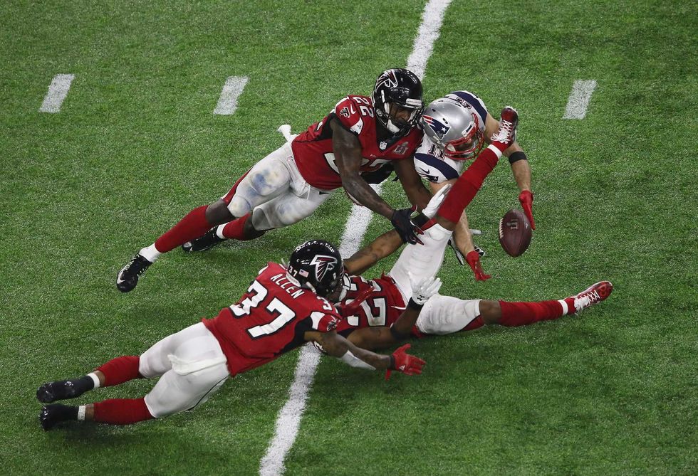 Julian Edelman #11 of the New England Patriots makes a 23 yard catch in the fourth quarter against Ricardo Allen #37, Robert Alford #23 and Keanu Neal #22 of the Atlanta Falcons during Super Bowl 51 at NRG Stadium on February 5, 2017 in Houston, Texas.