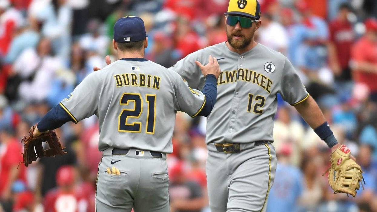 Jun 1, 2025; Philadelphia, Pennsylvania, USA; Milwaukee Brewers third base Caleb Durbin (21) and first base Rhys Hoskins (12) celebrate win against the Philadelphia Phillies at Citizens Bank Park. Mandatory Credit: Eric Hartline-Imagn Images