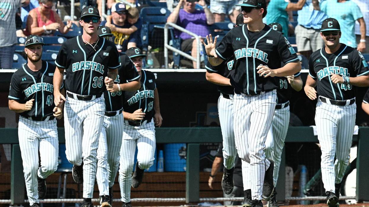 Jun 18, 2025; Omaha, Neb, USA; The Coastal Carolina Chanticleers bench runs on the field after the win against the Louisville Cardinals at Charles Schwab Field.