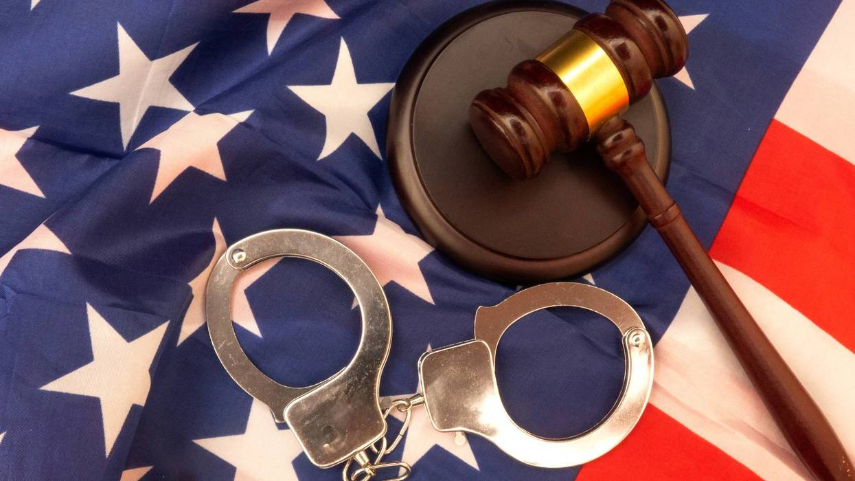 Justice in Untied States of America symbolized with handcuffs and gavel on the American flag