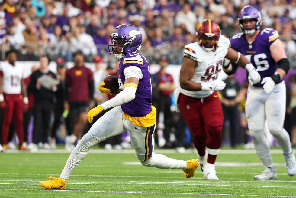 Justin Jefferson #18 of the Minnesota Vikings runs with the ball during the first half against the Washington Commanders at U.S. Bank Stadium on December 07, 2025 in Minneapolis, Minnesota.
