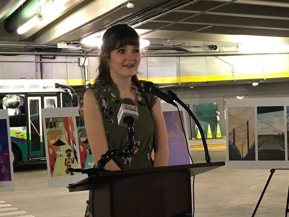 Kacy Lyvers, chair of Greenville City Youth Commission, speaks at ceremony for inaugural Bus Shelter Art Contest winners.