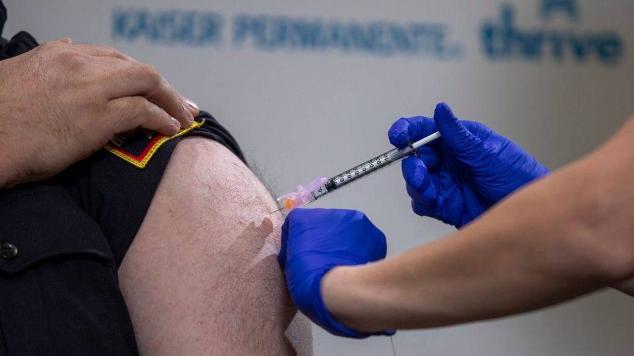 Kaiser Permanente registered nurse Corie Robinson administers the Pfizer-BioNTech COVID-19 vaccine to DC Fire and EMS Lieutenant Joseph Papariello during a vaccine event at Kaiser Permanente Capitol Hill December 17, 2020 in Washington, DC.