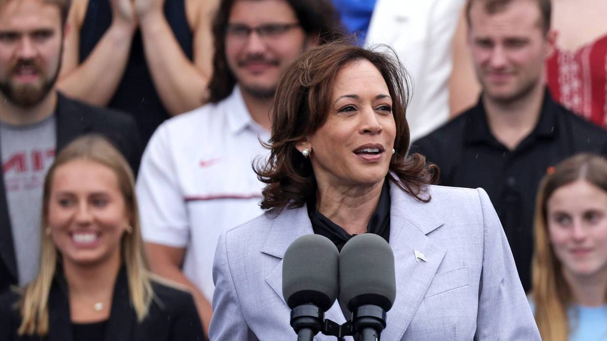kamala harris at microphone with crowd of people behind her