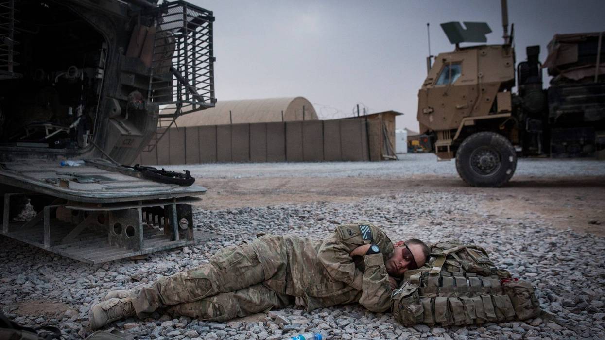 KANDAHAR, AFGHANISTAN - MARCH 18: A soldier in the U.S. Army's 1st Battalion, 36th Infantry Regiment, Charlie Company naps during a maintenance stop at Forward Operating Base Azzizulah on March 18, 2013 in Kandahar Province, Maiwand District, Afghanistan.