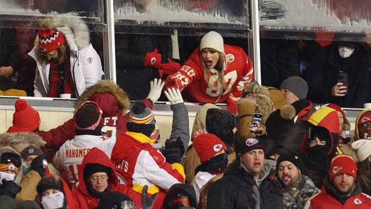 KANSAS CITY, MISSOURI - Taylor Swift celebrates with fans during the AFC Wild Card Playoffs between the Miami Dolphins and the Kansas City Chiefs at Arrowhead Stadium on January 13, 2024