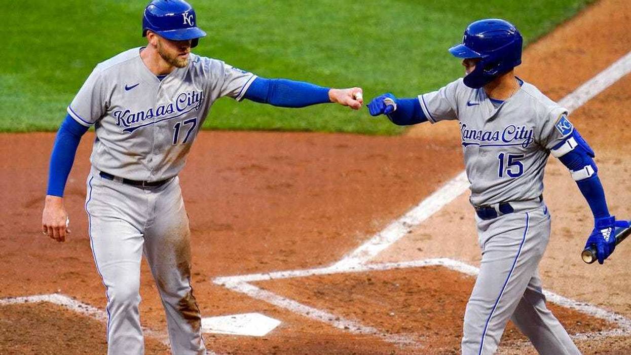 Kansas City Royals' Hunter Dozier (17) gets a fist bump from Whit Merrifield after scoring on a double by Michael Taylor