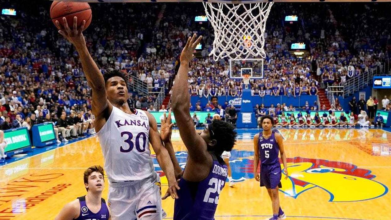 Kansas guard Ochai Agbaji (30) gets past TCU center Souleymane Doumbia (25) to put up a shot