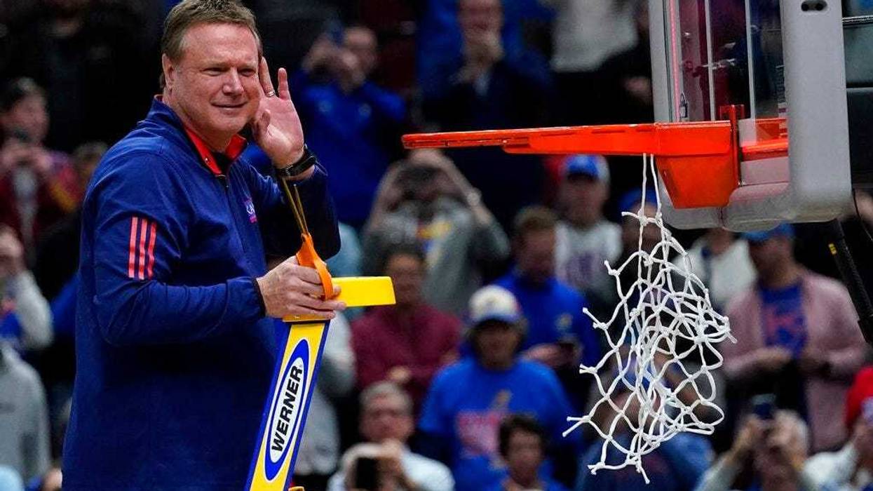 Kansas head coach Bill Self cuts down the net after a college basketball game in the Elite 8 round of the NCAA tournament against Miami