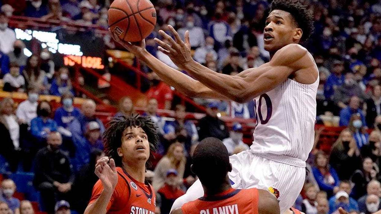 Kansas's Ochai Agbaji shoots over Stony Brook's Elijah Olaniyi and Frankie Policelli