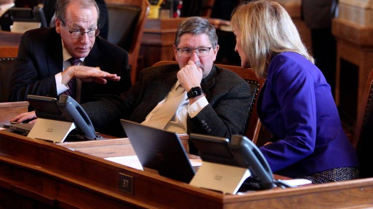 Kansas state Reps. Mark Schreiber, left, R-Emporia; Carl Maughan, center, R-Colwich, and Susan Humphries, right, R-Wichita, confer during a House vote on overriding Gov. Laura Kelly's veto of a tax plan