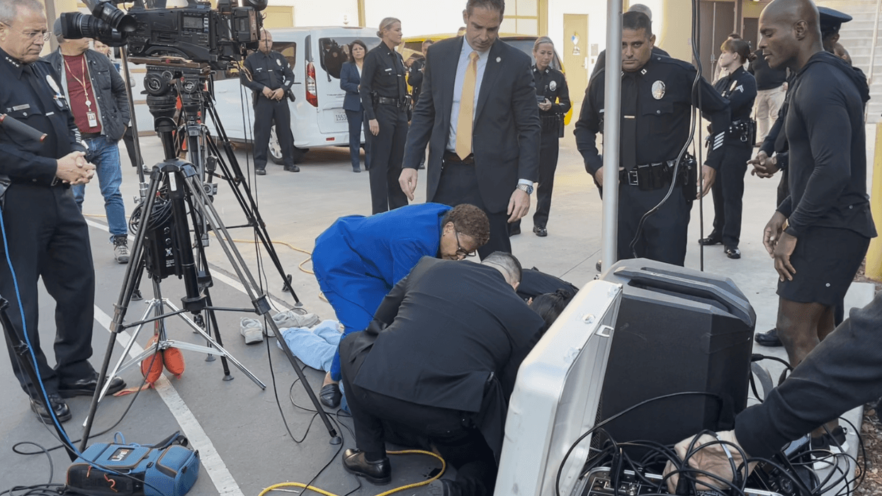 karen bass helps man lying on ground