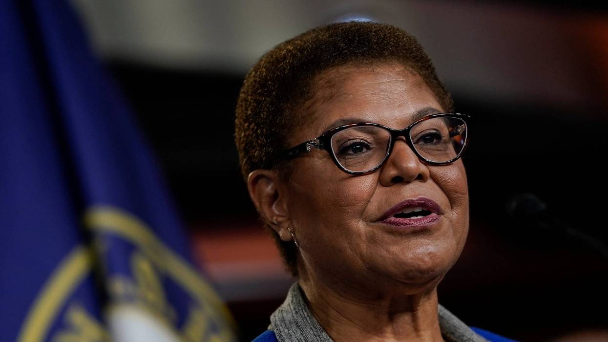 karen bass speaks in front of flag