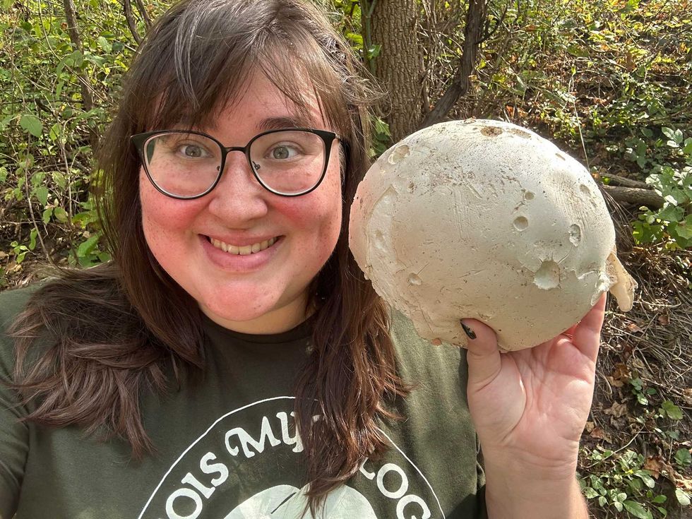 Kate Golembiewski poses with a giant puffball, the Illinois State Mushroom. The giant puffball will be on display at the Chicago Botanic Garden Sunday as part of the Illinois Mycological Association