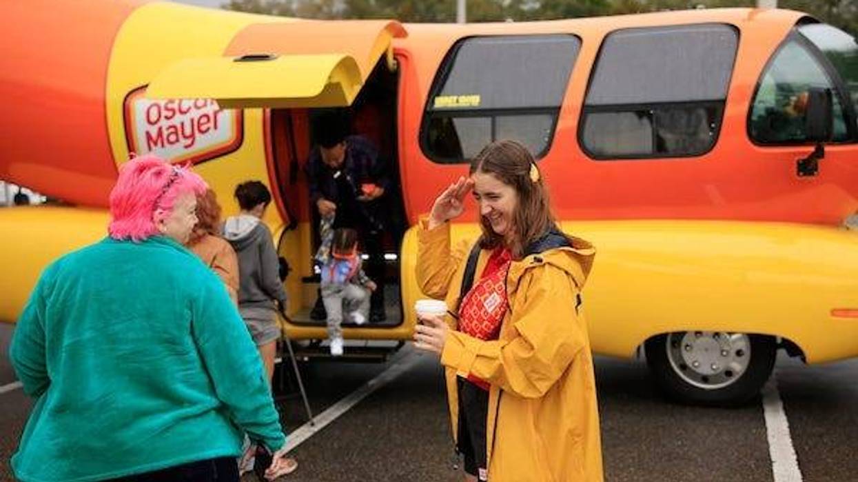 Katherine "Sauerkraut Kat" Abraham salutes patrons as Terri Hubner, left, looks on outside the Oscar Mayer Wienermobile Friday, Feb. 3, 2023 at the Jacksonville Humane Society in Jacksonville, Fla