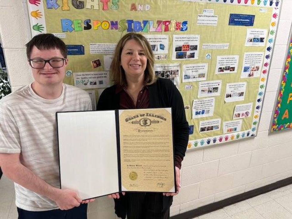 Kathryn Lavin and student holding a proclamation from Governor Pritzker.