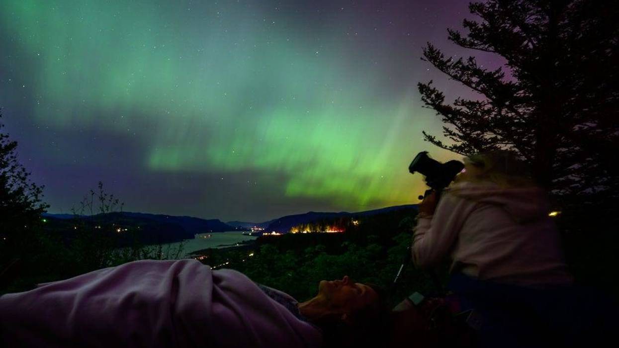 Kathryn Richer (left) and her friend Andrea gaze upon the Northern Lights at Chanticleer Point Lookout on the Columbia River Gorge in the early morning hours of May 11, 2024 in Latourell, Oregon. Places as far south as Alabama and parts of Northern California were expected to see the aurora borealis, also known as the northern lights from a powerful geomagnetic storm that reached Earth. (Photo by Mathieu Lewis-Rolland/Getty Images)
