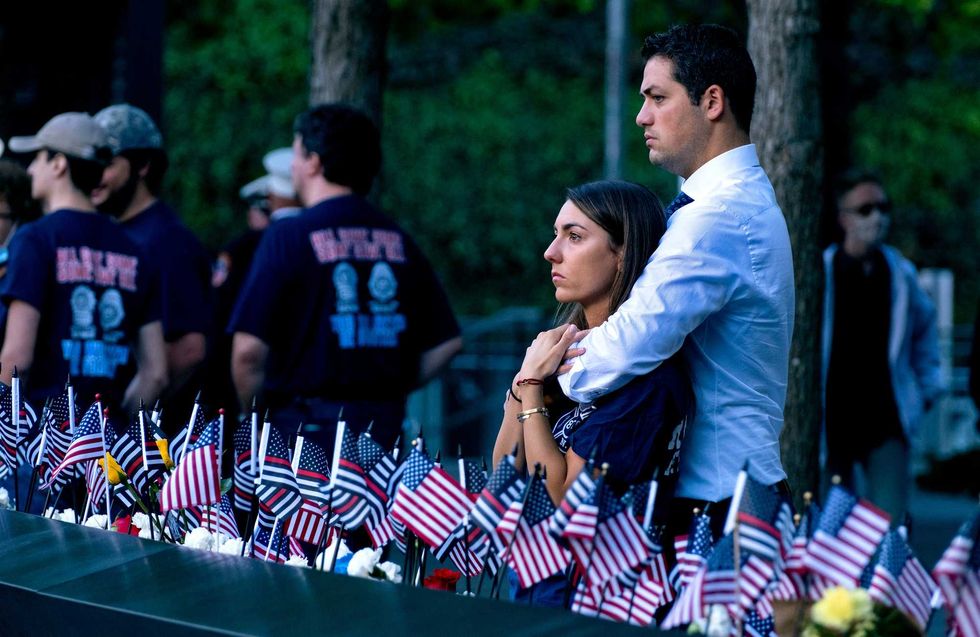 Katie Mascali is comforted by her fiance Andre Jabban as they stand near the name of her father Joseph Mascali during a ceremony at the National September 11 Memorial & Museum commemorating the 20th anniversary of the September 11th terrorist attacks on the World Trade Center on September 11, 2021 in New York City