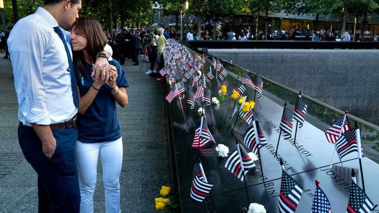 Katie Mascali is comforted by her fiance Andre Jabban as they stand near the name of her father Joseph Mascali during a ceremony at the National September 11 Memorial & Museum commemorating the 20th anniversary of the September 11th terrorist attacks on the World Trade Center on September 11, 2021 in New York City.