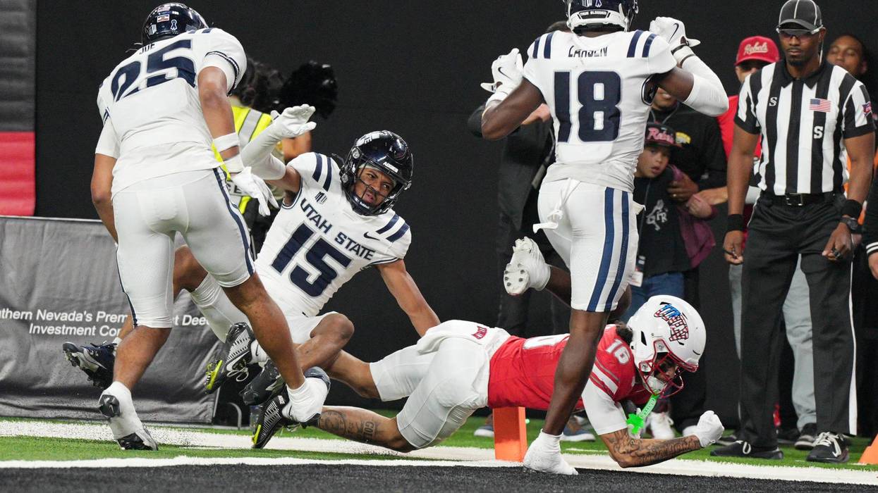 Kayden McGee #16 of the UNLV Rebels scores the game-winning touchdown in double overtime to defeat the Utah State Aggies 29-26 at Allegiant Stadium on November 15, 2025 in Las Vegas, Nevada.