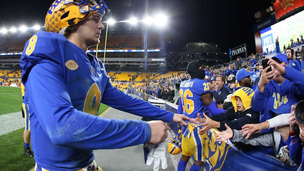 Kenny Pickett (8) gives his gloves to a fan after defeating the Clemson Tigers