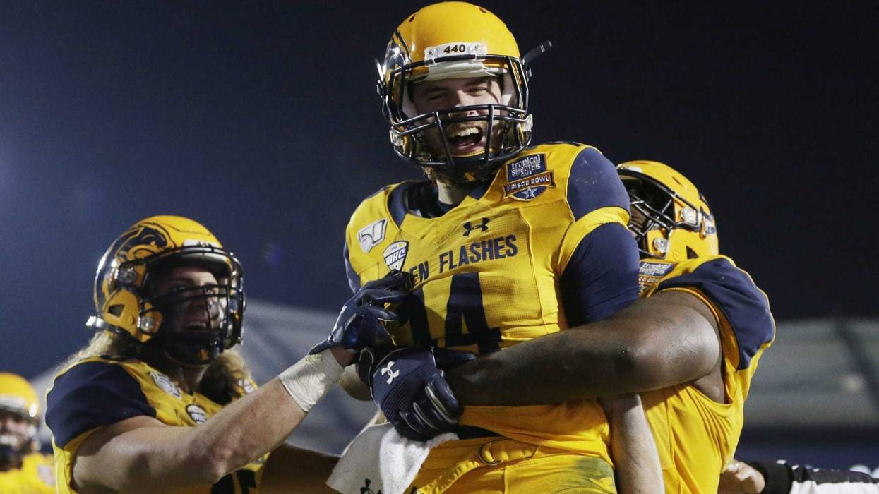 Kent State Golden Flashes quarterback Dustin Crum (14) celebrates a touchdown with offensive lineman Julian Sams (55) in the fourth quarter against the Utah State Aggies during the Frisco Bowl at Toyota Stadium.