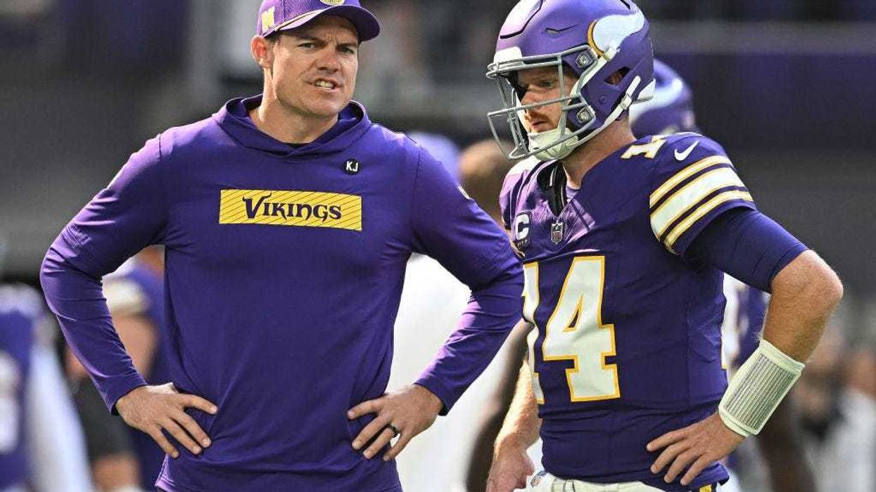 Kevin O'Connell, head coach of the Minnesota Vikings, speaks to quarterback Sam Darnold #14 before the game against the Houston Texans at U.S. Bank Stadium on September 22, 2024 in Minneapolis, Minnesota.