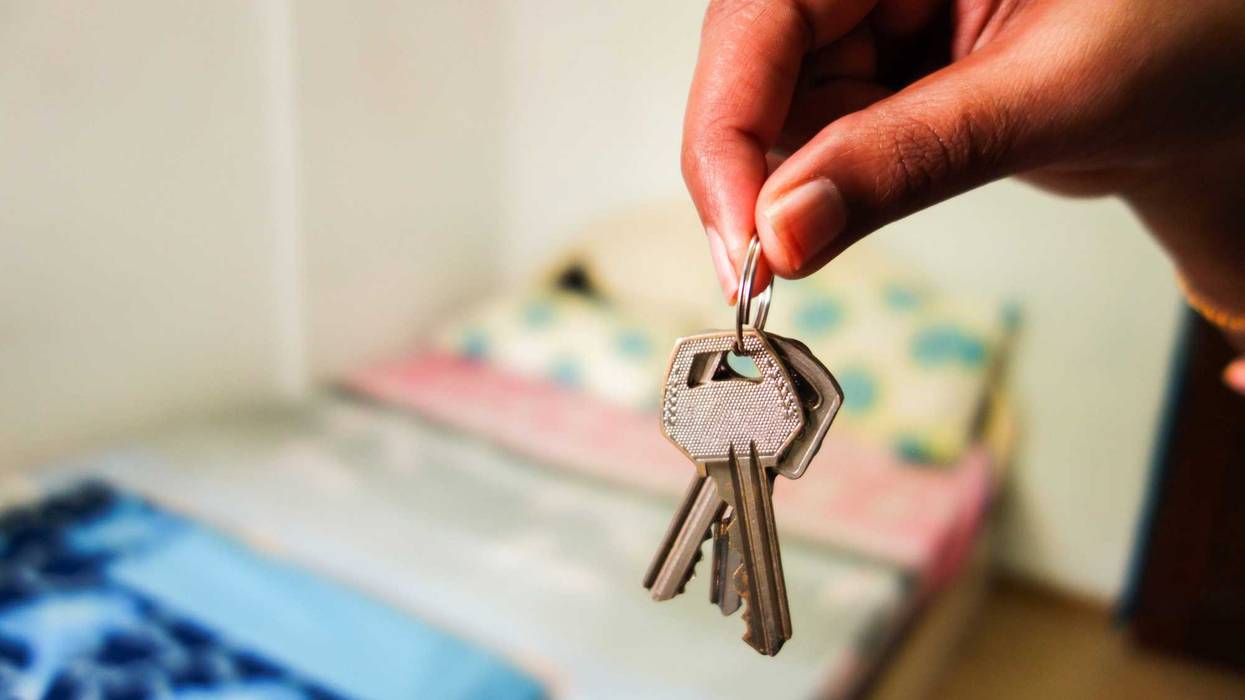 Keys in front of a bed, background blurred.