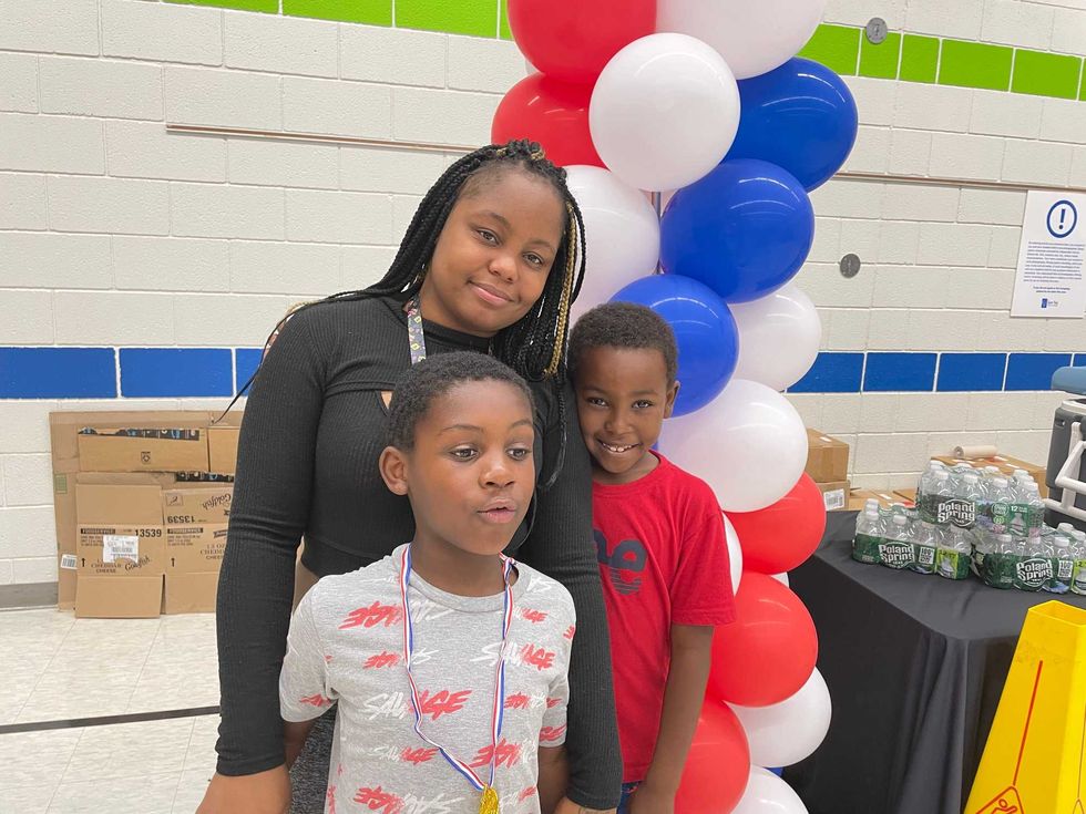Kianna Vaughn poses with her son, Cordell Brown (with Olympic necklace) and nephew