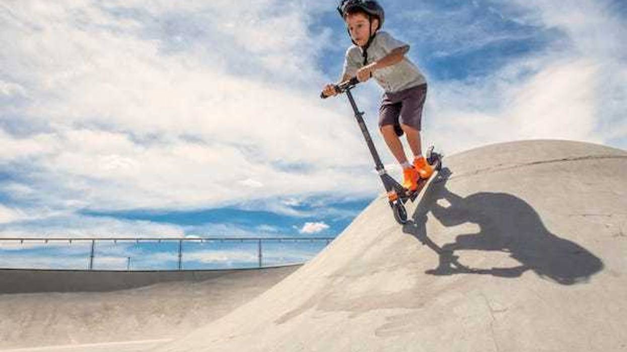 Kid going down a ramp on a scooter