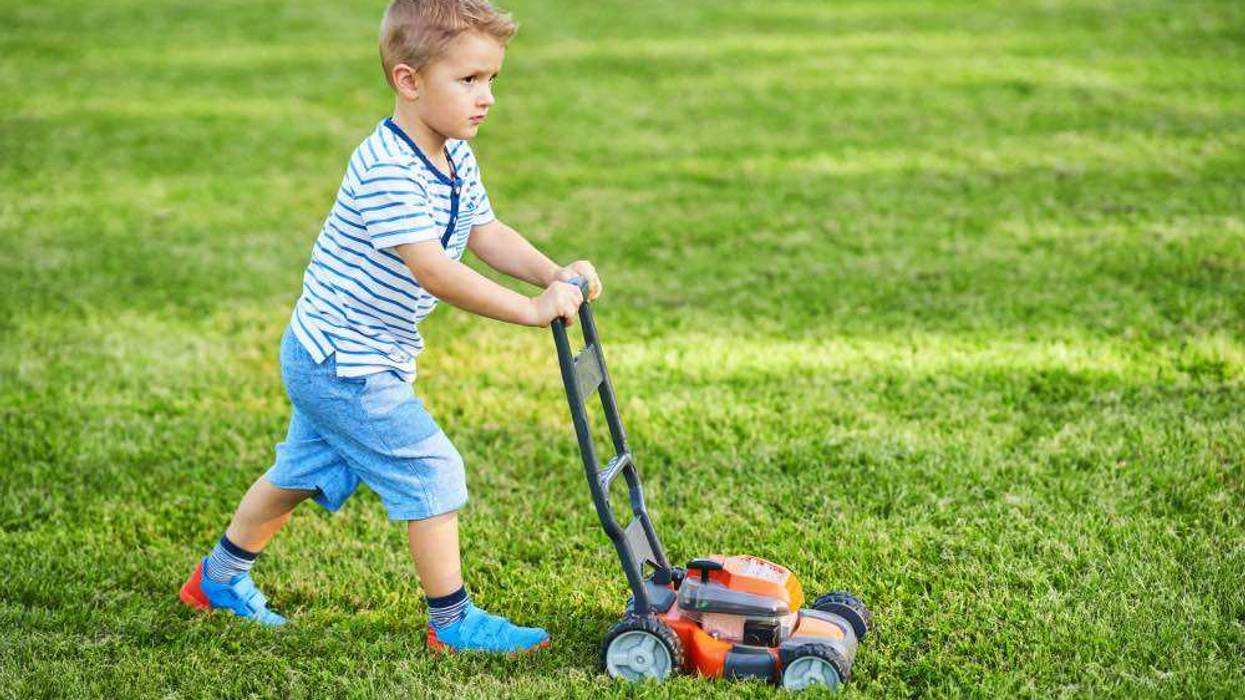 kid mowing grass