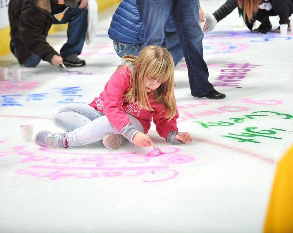 kid painting message on ice at Penguins game