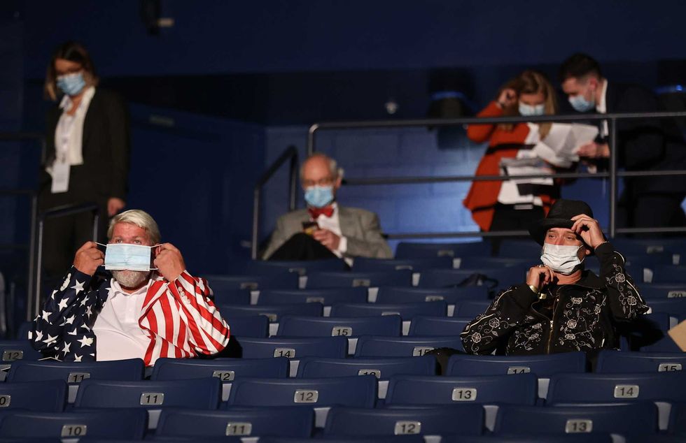 Kid Rock (R) and John Daly put on masks after being asked to wear them, at the final presidential debate between U.S. President Donald Trump and Democratic presidential nominee Joe Biden at Belmont University on October 22, 2020 in Nashville, Tennessee. This is the last debate between the two candidates before the election on November 3.