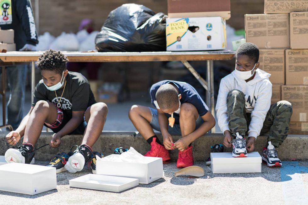 Kids at a summer kick-off event try on shoes.