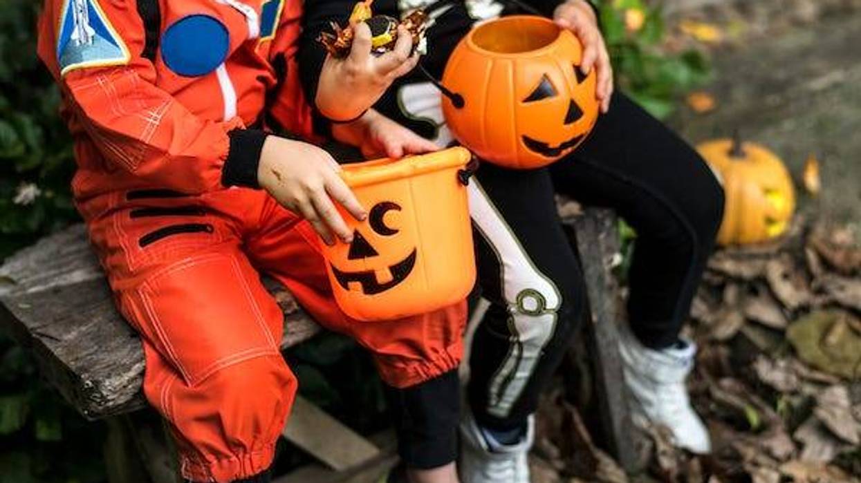 Kids holding candy and Halloween buckets while trick-or-treating