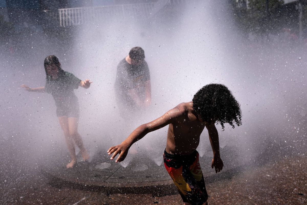 Kids play in the Salmon Springs Fountain in Portland amid a heat wave.