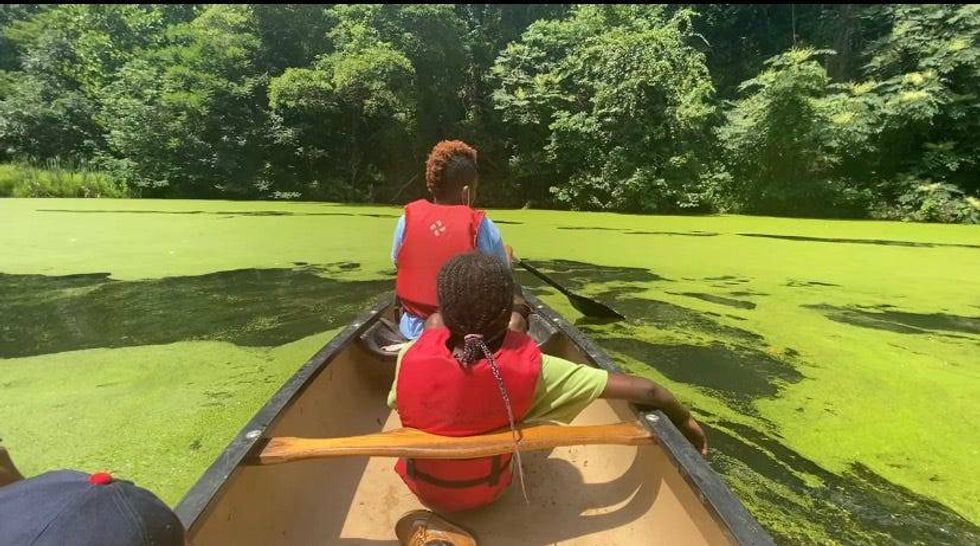 Kids row a boat at Camp Excellence