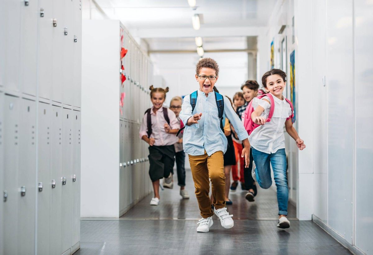 Kids running through school corridor