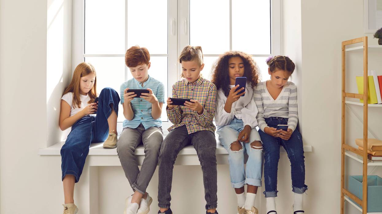 kids sitting while on cell phones