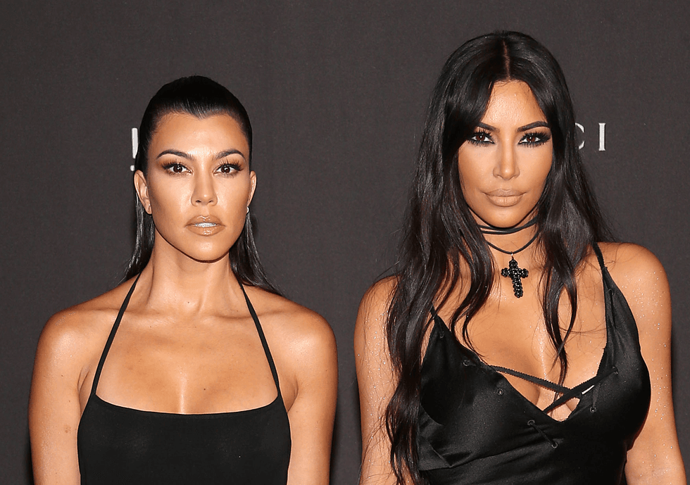 Kim Kardashian twins with sister Kourtney in plunging cobalt blue swimsuit