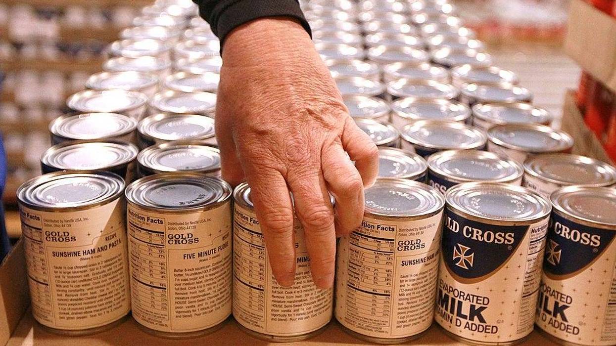 Kim Kinker packs cans of evaporated milk into boxes while volunteering with members of the San Francisco 49ers at the San Francisco Food Bank on November 9, 2010 in San Francisco, California.