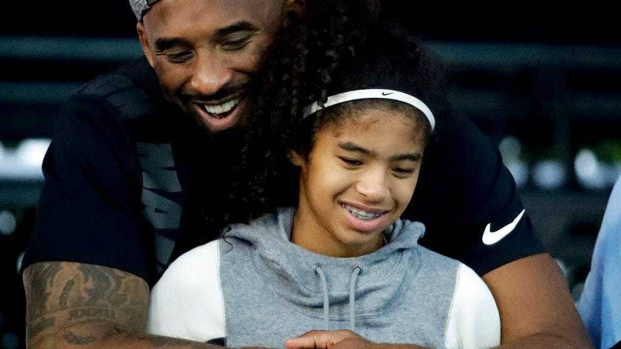 Kobe Bryant and his daughter Gianna watch during the U.S. national championships swimming meet in Irvine, Calif. Federal investigators say wreckage from the helicopter that crashed last month and killed Bryant, his daughter and seven others did not show a