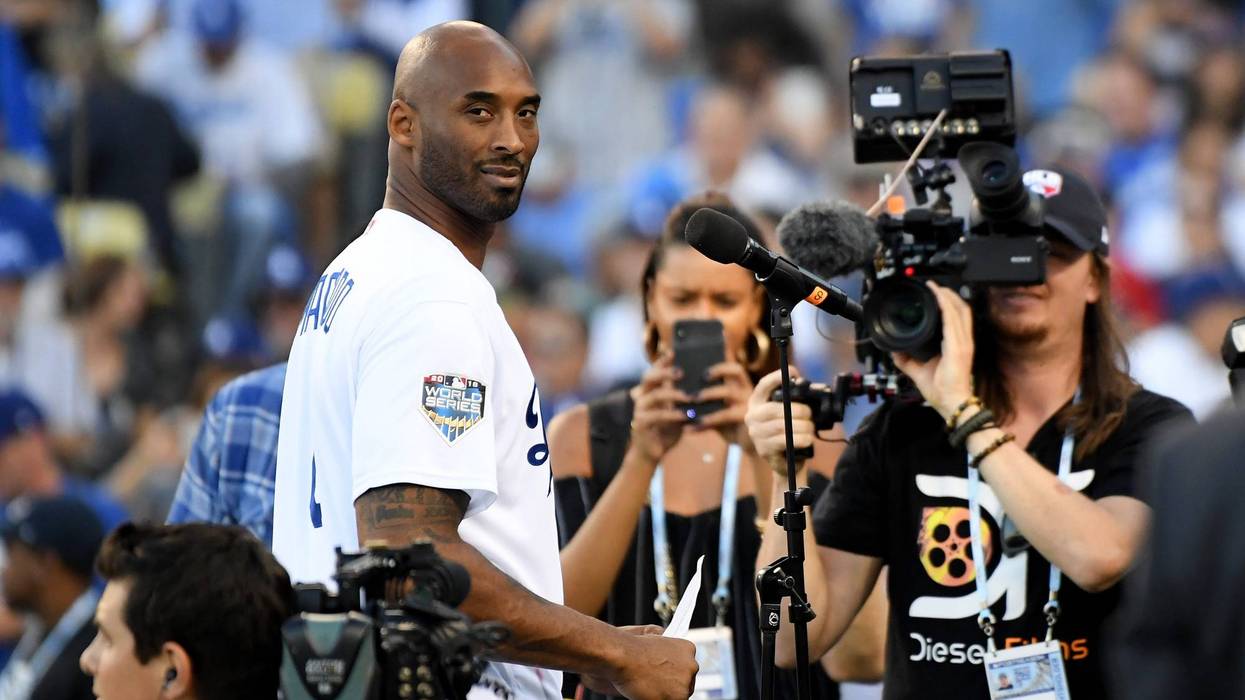 kobe bryant wearing a dodgers jersey in front of cameras at dodgers stadium