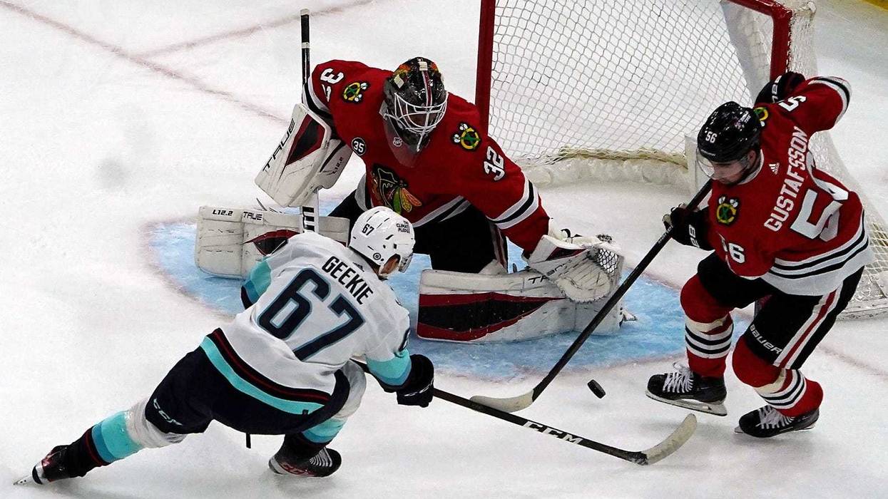 Kraken center Morgan Geekie (67) shoots the puck on Blackhawks goaltender Kevin Lankinen (32).