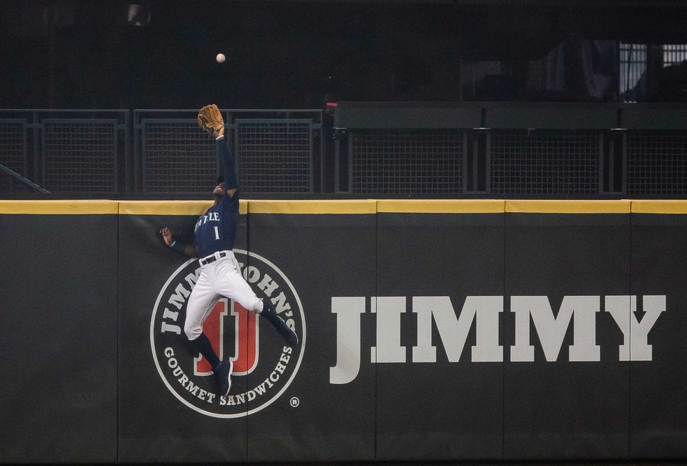 Kyle Lewis scales the center-field wall for a leaping catch